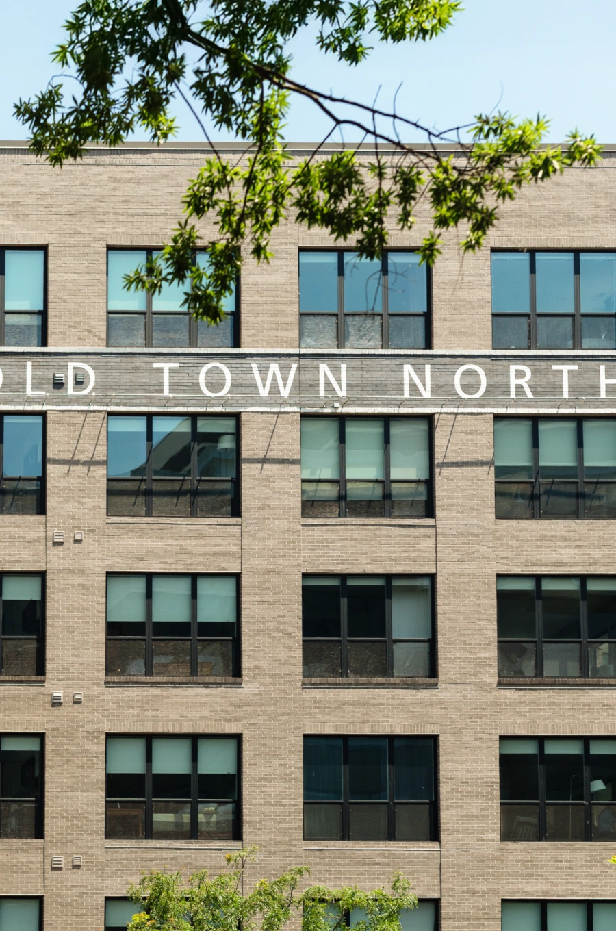 Mid-rise apartment block with symmetrical windows and Old Town North signage in white letters