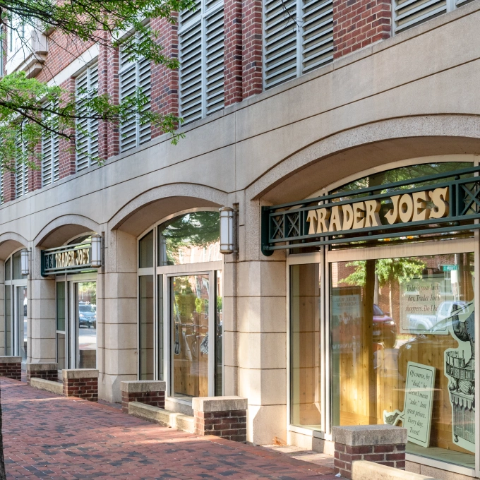 Trader Joe’s storefront with reflective windows and tan brick exterior on quiet urban street