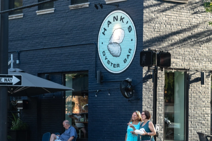 Hank’s Oyster Bar restaurant with blue painted brick exterior and large oyster logo sign